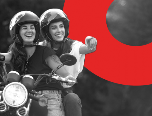 Capa do artigo modelos de moto | DOK Despachante | Descrição: duas mulheres em cima de uma moto, a que está na garupa aponta para o horizonte, ambas sorriem e usam capacete.